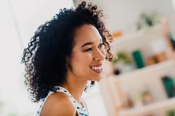 Young woman smiling indoors in a cozy apartment with modern decor on a bright day