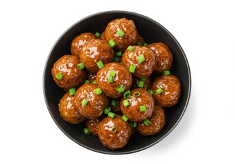 Meatballs in a dark bowl topped with chopped green onions on a white background