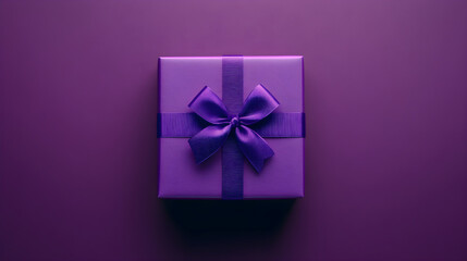 Purple gift box with satin ribbon and bow on monochromatic purple background