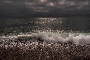 Dark storm clouds over ocean. Dramatic seascape. Clouds and rain flurry over sea.