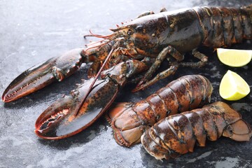 Raw lobster, tails and lime on dark table, closeup