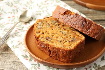 Pieces of homemade carrot cake with nuts and spoon on wooden table, closeup