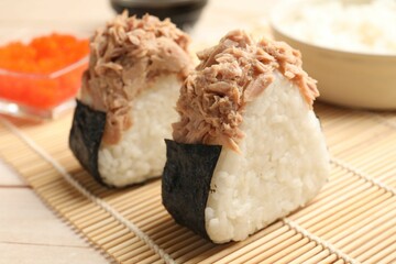 Tasty onigiri (Japanese rice balls) with tuna served on table, closeup