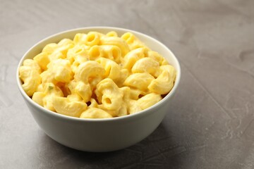 Delicious pasta with cheese sauce in bowl on grey table, closeup. Space for text
