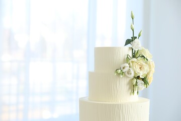 Delicious wedding cake with floral decor indoors, closeup. Space for text