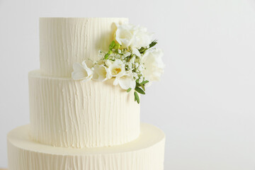 Delicious wedding cake with floral decor on white background, closeup. Space for text
