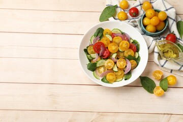 Fresh salad with yellow tomatoes served on wooden table, flat lay. Space for text