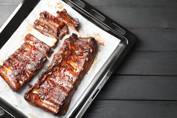 Delicious spare ribs on grey wooden table, top view