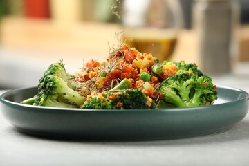 Adding spices to dish at light table indoors, closeup