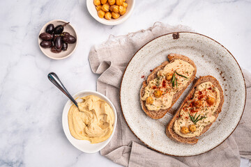 Delicious sandwiches with hummus and ingredients on white table, top view, flat lay. High quality photo