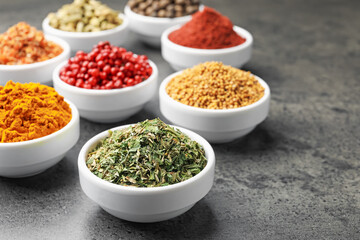 Different aromatic spices on grey table, closeup