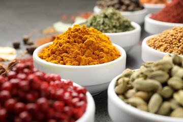 Different aromatic spices on grey table, closeup