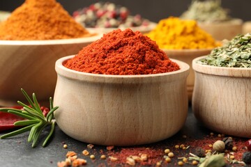 Different aromatic spices on black table, closeup