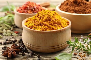 Different aromatic spices on wooden table, closeup