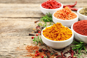 Different aromatic spices on wooden table, closeup. Space for text