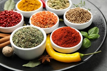 Different aromatic spices on grey table, closeup