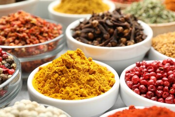 Different aromatic spices in bowls on table, closeup