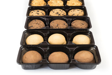Various round cookies in an open box. Cookies in a pack on white