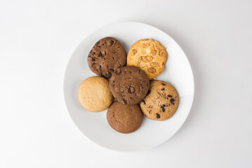 Different round cookies in a white plate on a white background