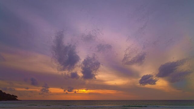 Time lapse A breathtaking sunset over a tropical beach, casting golden hues across the sky and reflecting on the calm ocean waters. Silhouettes of people walking along the shore add a peaceful.