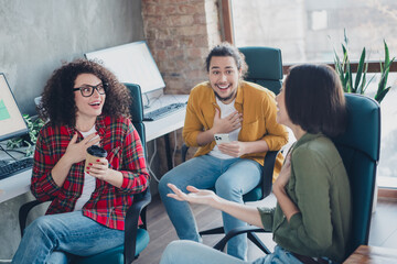 Young professionals engaging in collaborative conversation at a creative workspace environment with casual attire