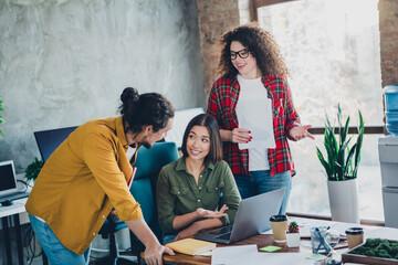 Young colleagues collaborating actively in a modern office setting, discussing ideas around a desk