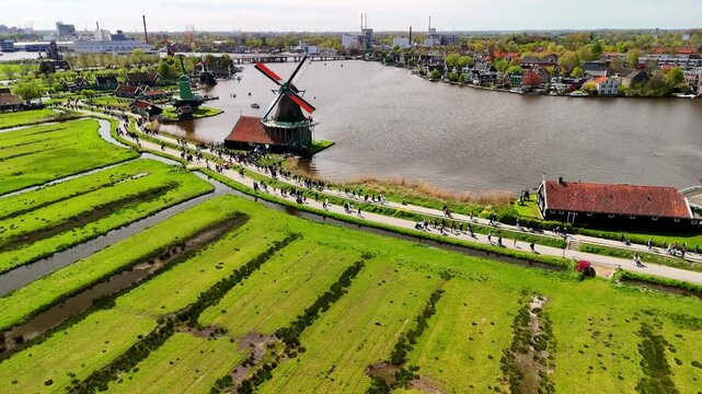  Aerial drone view of beautiful wooden windmills in the Dutch village of Zaanse Schans. The windmills run on wind. The Dutch canals are filled with water. Located near the city of Zaandam.