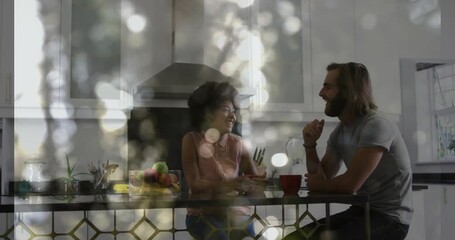 couple sitting at kitchen island, exploring health data with animated fruit bowl analytics overlay - Powered by Adobe