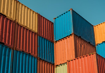 Fototapeta premium Vibrant, stacked shipping containers create a colorful and modern industrial display.