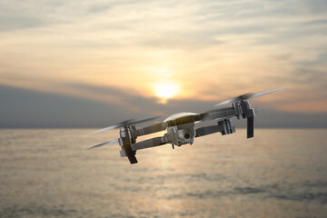 Drone with camera flying over sea. Unmanned aerial vehicle for surveillance