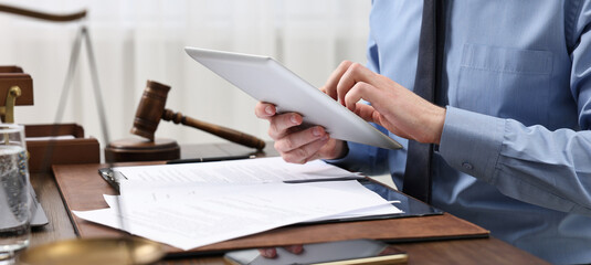 Judge working on tablet at wooden table, closeup. Banner design