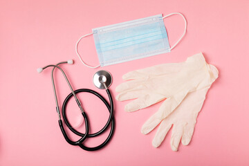 Medical nitrile gloves,blue cap, disposable medical mask on textured background. Medic protective clothing. Surgical latex gloves. Rubber gloves manufacturing.Medicine concept. Top view. Copy text