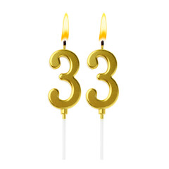 Burning golden cake candles composing number 33 on white background. Festive decoration for...