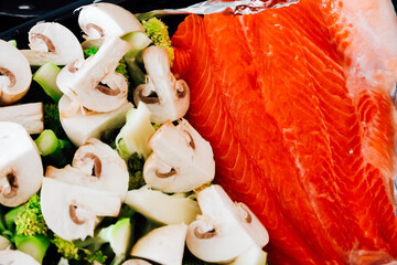 Fresh salmon and vegetables prepared for a healthy cooking session at home kitchen