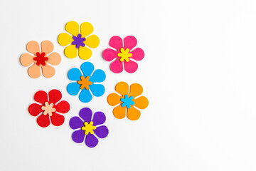 Colorful paper flowers arranged creatively on a white background for decoration or craft ideas