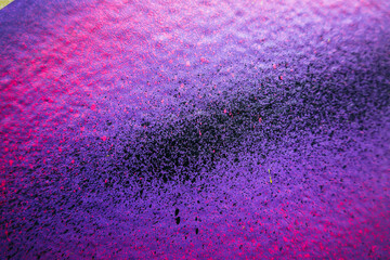 Abstract urban street art background. Painted wall in purple, pink and black colors. Part of graffiti on building wall