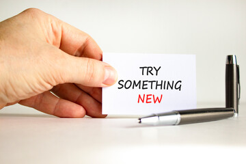 Try something new symbol. Concept words Try something new on beautiful note. Beautiful white background. Businessman hand, pen. Business motivational lifestyle try something new concept. Copy space.