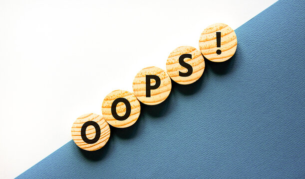 Oops symbol. Concept word Oops on beautiful wooden circles. Beautiful blue and white background. Business lifestyle oops concept. Copy space.