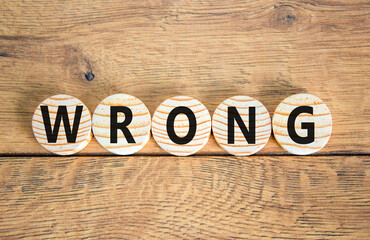 Fototapeta premium Wrong symbol. Concept word Wrong on beautiful wooden circles. Beautiful wooden table wooden background. Business lifestyle wrong concept. Copy space.