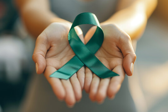 In honor of world mental health day and to raise awareness for cervical, kidney cancer, and lymphoma, the womans hands are adorned with the green ribbon symbol - Powered by Adobe