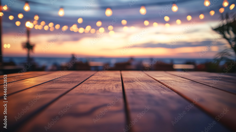 Poster dark brown wooden table at sunset, blurred background with string lights and ocean view, showcasing 