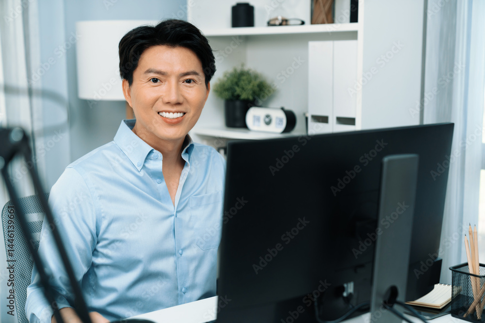 Poster portrait of smart businessman looking camera to pose while working on computer checking email wearin