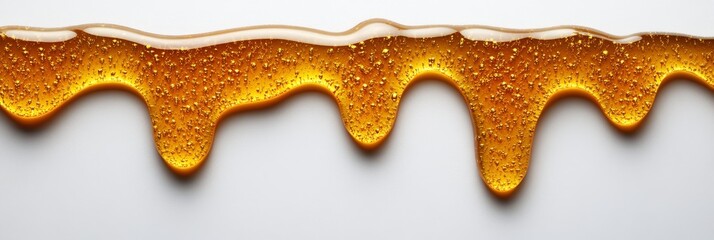 Obraz premium An abstract background featuring golden honey drips with droplets on a smooth white surface