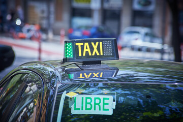 Spanish Barcelona Taxi sign close-up view with the street view with the unfocused depth of field...