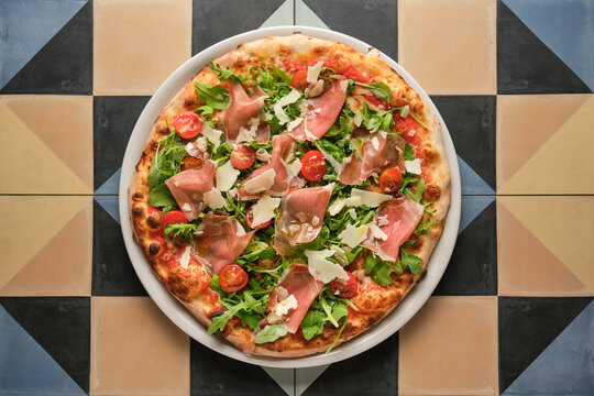 Delicious pizza with parma ham, rocket and cherry tomatoes