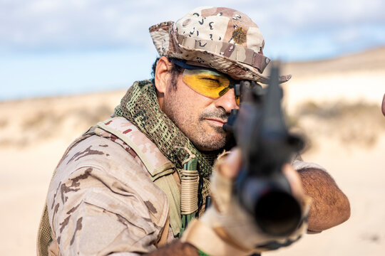 Soldier in Desert Camouflage Aiming Rifle with Focused Expression