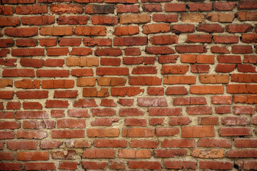 Obraz premium An old shabby red brick wall background. Close up.