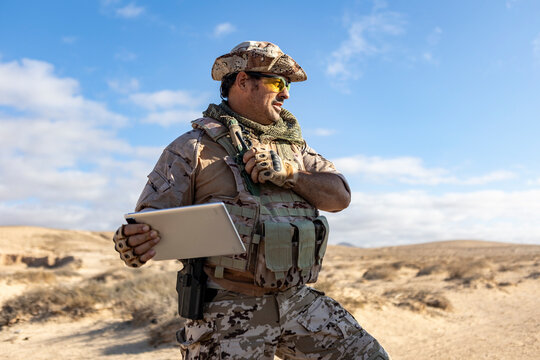 Military soldier using technology in desert terrain