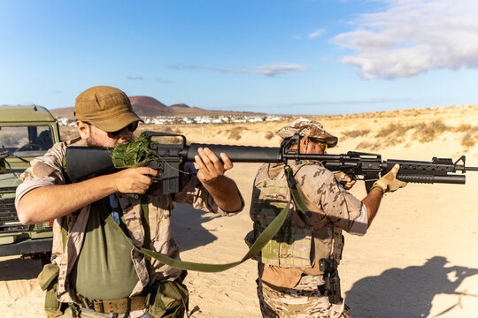 Armed men in desert military training exercise gear