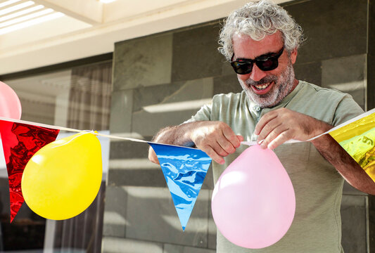 Man Setting Up Colorful Birthday Decorations Outdoors